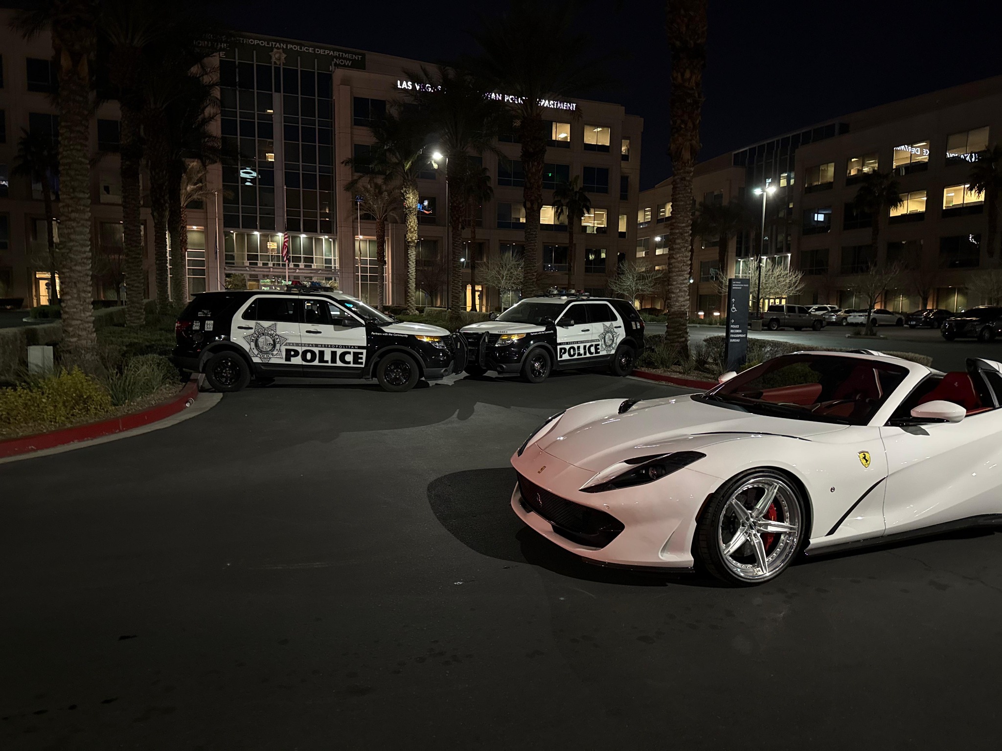 A white Ferrari photographed on a city street at night.